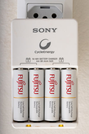 Cassilandia, Mato Grosso do Sul, Brazil - 01 08 2020: Sony charger in the socket charging four fujitsu AA batteriesのeditorial素材