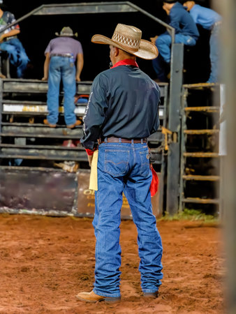 Itaja, Goias, Brazil - 04 22 2023: Person at a bull riding event in a rodeo arena at night
