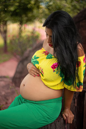 Pregnant woman posing in female photoshoot in a parkの写真素材