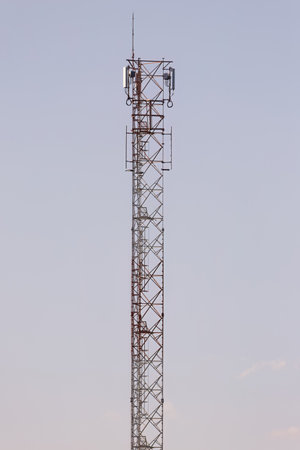 Large metallic telecommunications tower with gray sky in the background