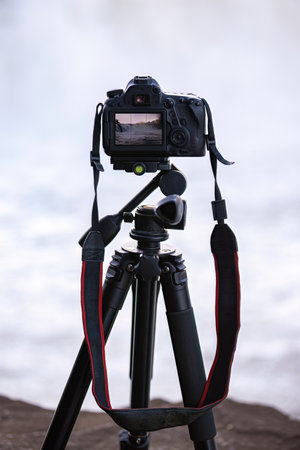 close up of photo camera on tripod to photograph a waterfall selective focusの写真素材