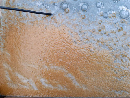 water surface in aquarium with bubbles and rust due to an experiment electrolysis process to remove...