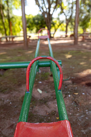 green and red metal seesaw in park playground