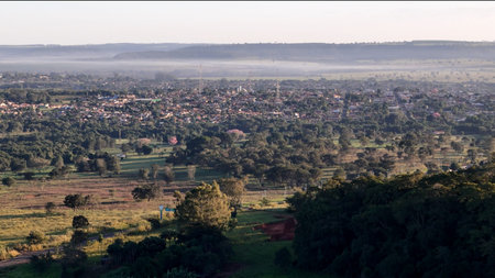 Cassilandia, Mato Grosso do Sul, Brazil - 04 05 2024. Drone aerial panorama of the town surrounded by rural landscape with morning mist and sunrise light illuminating the urban area.の写真素材