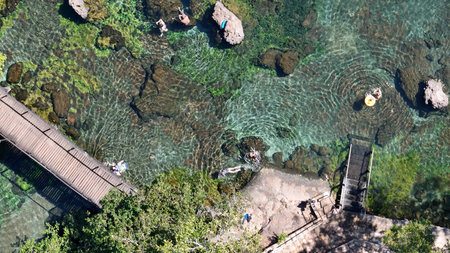 Lagoa Santa, Goias, Brazil - 07 05 2024. Drone aerial close-up view of the clear water lagoon with rocks wooden walkways and tourists swimming at Thermas de Lagoa Santa.のeditorial素材