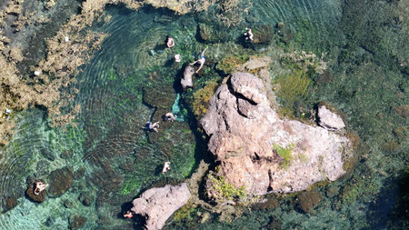 Lagoa Santa, Goias, Brazil - 07 05 2024. Drone top view of tourists swimming around rocky formations in the clear natural waters of Thermas de Lagoa Santa lagoon.のeditorial素材