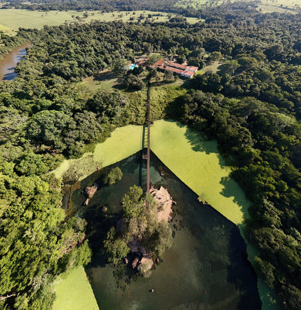 Lagoa Santa, Goias, Brazil - 07 05 2024. Wide aerial drone panorama showing the lagoon island connected by a wooden walkway and surrounded by dense riparian forest vegetation.のeditorial素材
