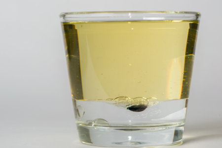 glass with drops of colored bubbles in water and oilの写真素材