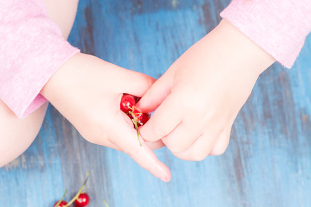 red currants on a wooden background in a hands around all summer bloomsの写真素材