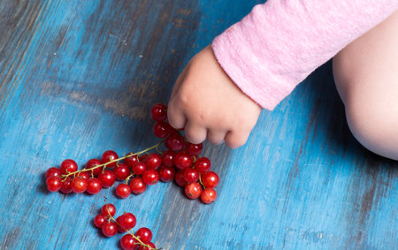 red currants on a wooden background in a hands around all summer bloomsの写真素材