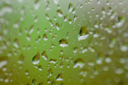 rain drops on glass flowing closeup shapeの写真素材