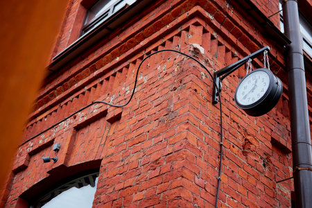 clock on a brick building on the street hangingの写真素材