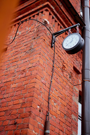 clock on a brick building on the street hangingの写真素材