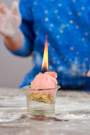 baby blows flour on a candle at the dough making cookies