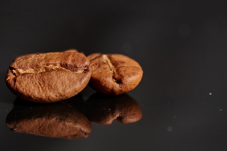coffee beans on black background consistent with the view in the macroの写真素材