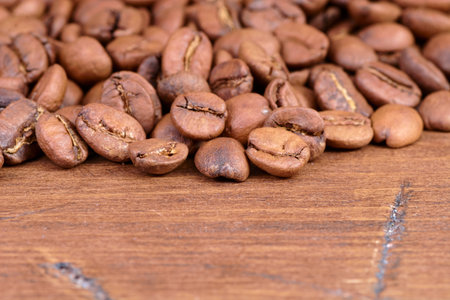 coffee beans on a wooden background scattered from the bagの写真素材