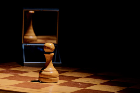 chess piece pawn looks in the mirror and sees the Queenの写真素材