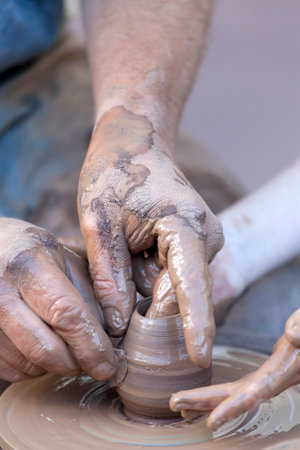 Pottery making. Hands working on pottery wheel.の写真素材