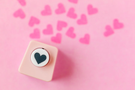 Decoration for Valentine's Day: hole puncher made paper shapes of pink heartsの写真素材