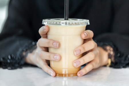 Woman holding in hands ice latte coffee, perfect summer cold beverageの写真素材