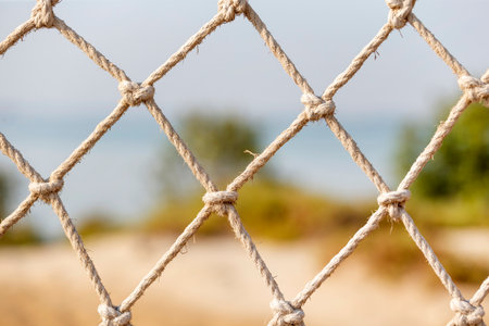Safety net, fence, woven mesh at the beachの写真素材
