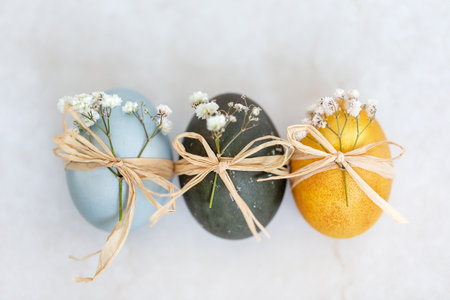 Baby blue, dark grey and yellow Easter eggs, top view closeup. Festive decoration.