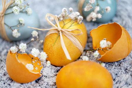 Colored Easter eggs and egg shells with spring flowers. Festive decoration.