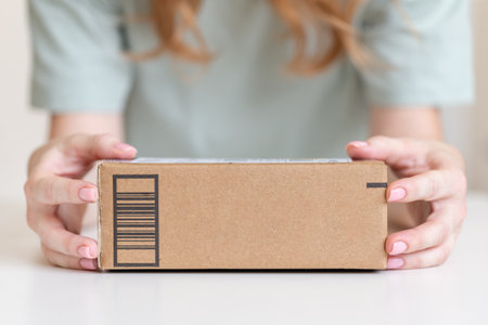 Young woman receiving goods delivered in cardboard boxの写真素材