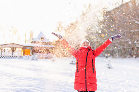 portrait of a girl walking in the winter outdoors. playing with snow.の写真素材