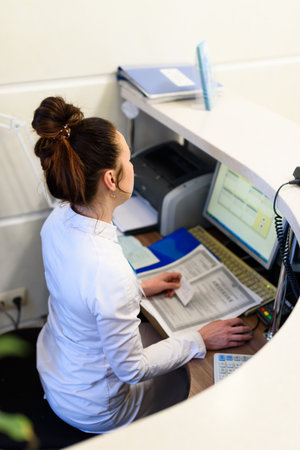 Female receptionist working the computer.の写真素材