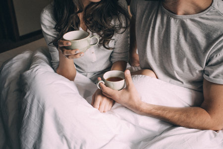 lovers holding together a Cup of tea.