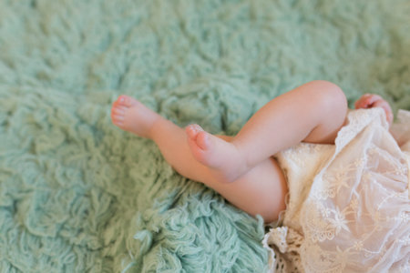 Baby feet in a green furの写真素材