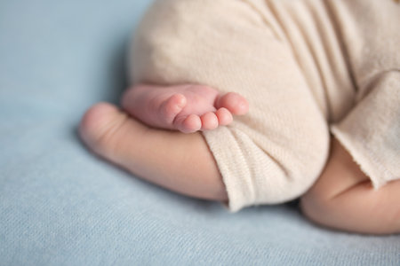 feet of a newborn baby. legs on a blue background. baby feetの写真素材