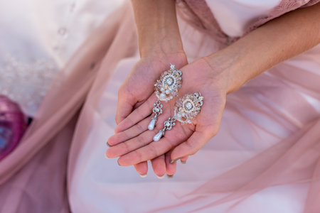 Bride holding earrings in the hands.の写真素材