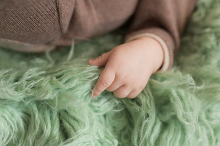 Baby little hand close-up in a green fur