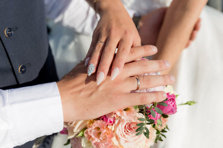 Picture of man and woman with wedding ring.Young married couple holding hands, ceremony wedding day. Newly wed couples hands with wedding ringsの写真素材