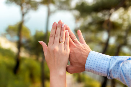 Wedding rings in the hands of the bride and groom on the sea background.