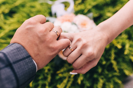 Picture of man and woman with wedding ring.Young married couple holding hands, ceremony wedding day. Newly wed couple's hands with wedding rings.の写真素材