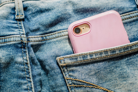 Modern smartphone in the pocket of jeans, close-up, Cell phone in the pocket of jeans in blue jeans,...