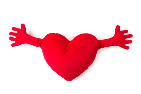 Close-up of red heart pillow with hands isolated.の写真素材