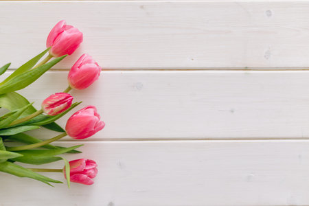Bouquet of pink tulips on white wooden background. Top view, copy space.の写真素材