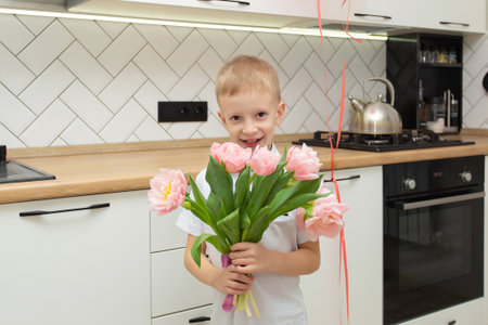Cheerful happy child with tulips flower bouquet. Smiling little boy on white background. Mother's Day, March 8, International Women's Day conceptの写真素材