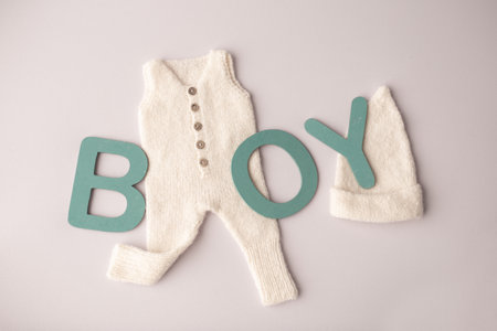 Inscriptions boy and white newborn clothes on the pink background. Horizontal top view.の写真素材