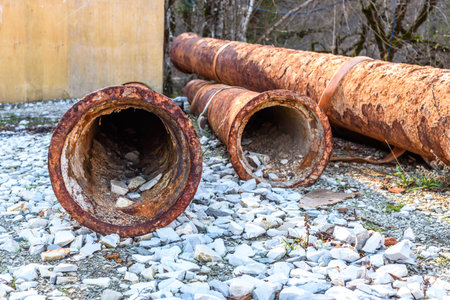 Pile of old rusty round metal industrial pipe.