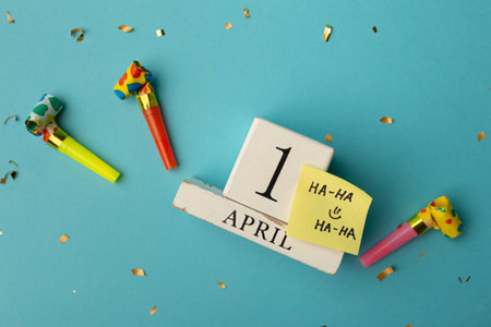 April 1st. Image of april 1 wooden calendar and festive decor on the blue background. April Fool's Day.の写真素材