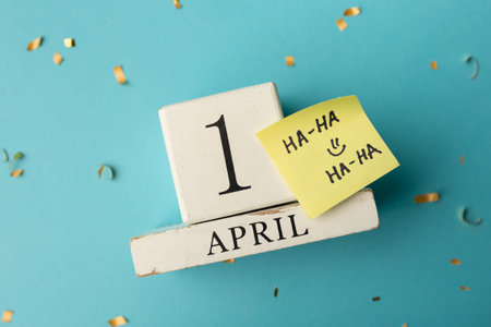 April 1st. Image of april 1 wooden calendar and festive decor on the blue background. April Fool's Day.の写真素材