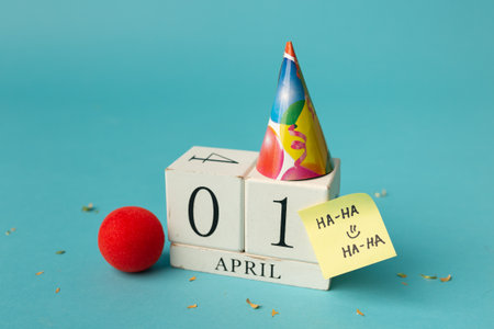 April 1st. Image of april 1 wooden calendar and festive decor on the blue background. April Fool's Day.の写真素材