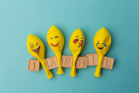 Creative minimalistic concept for April Fools' Day. wooden letters 1 april and festive decor on the blue background.の写真素材