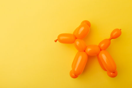 A bright little animal made of a balloon on yellow background. Concept April Fool's Day or Birthday.の写真素材