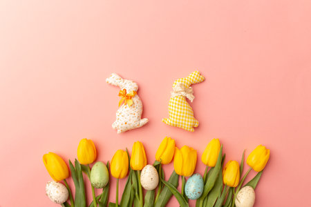 Yellow tulips and easter decor on a pink background, top view, spring bouquet. Easter postcard.の写真素材
